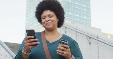 Mutlu ve melez bir kadın akıllı telefon kullanıyor ve kahve içiyor. dijital göçebe hareket halinde, beden içeriği.