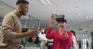 Ofiste VR kulaklığı kullanan mutlu erkek ve kadın iş arkadaşları. Modern bir ofiste çalışmak..
