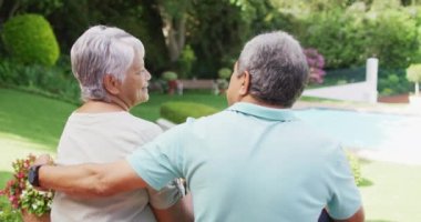 Arka planda çiftler arası yaşlı çiftlerin bahçede kucaklaşmalarını gösteren bir video. aktif emeklilik yaşam tarzı, kıdemli ilişki ve birlikte zaman geçirme kavramı.