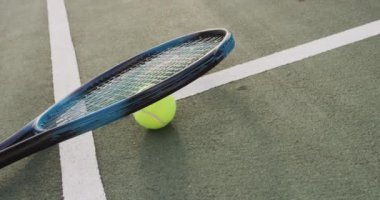 Tenis kortunda duran tenis raketi ve topunun videosu. aktif yaşam tarzı, spor, hobi ve tenis eğitimi kavramı.