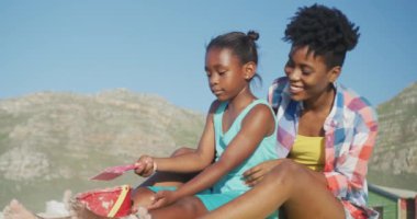 Mutlu Afro-Amerikan annesi güneşli plajda kızıyla oynuyor. sağlıklı ve aktif zaman plaj tatili.