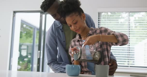 Afro Amerikalı Mutlu Çiftin Kahve Hazırlayıp Evde Kucaklaşmalarını Gösteren Bir — Stok video