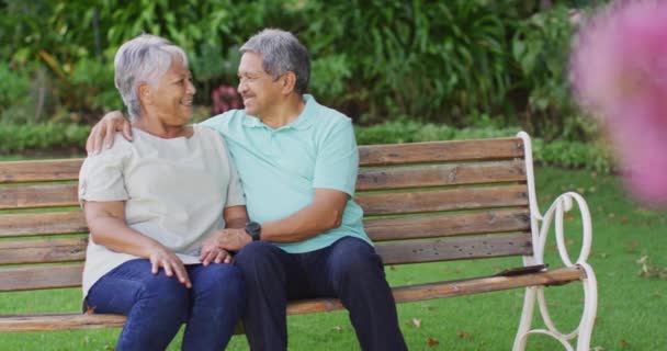 Video Feliz Pareja Ancianos Birraciales Abrazando Sentado Banco Jardín Estilo — Vídeos de Stock