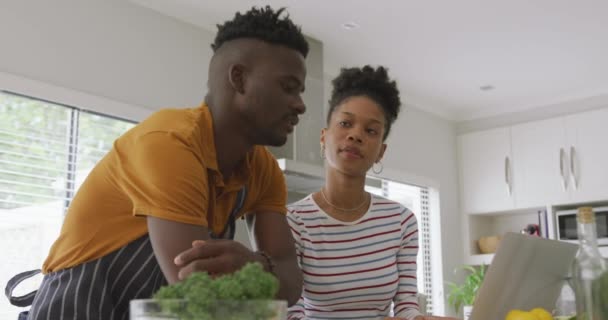 幸せなアフリカ系アメリカ人のカップルのビデオは タブレットとキッチンで一緒に調理します 家庭で質の高い時間を過ごすことです — ストック動画