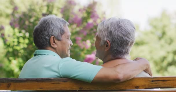 Video Feliz Pareja Ancianos Birraciales Abrazando Sentado Banco Jardín Estilo — Vídeos de Stock