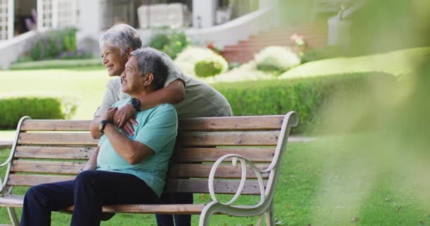 Video Feliz Pareja Ancianos Birraciales Abrazando Sentado Banco Jardín Estilo — Vídeos de Stock