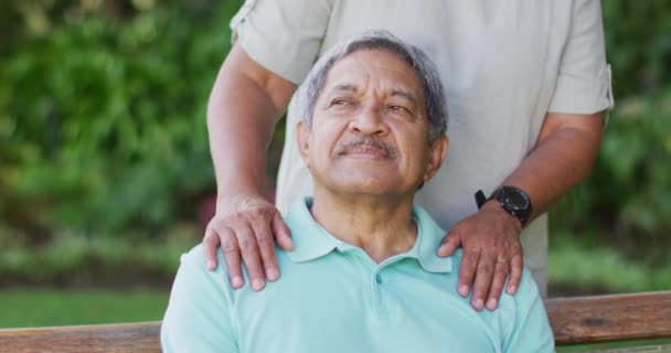 Video Feliz Pareja Ancianos Birraciales Abrazando Sentado Banco Jardín Estilo — Vídeos de Stock