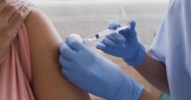 Afro-Amerikan kadın doktorunun orta bölümü evde yaşlı bir kadına iğne yapıyor. tıbbi sağlık hizmeti kavramı