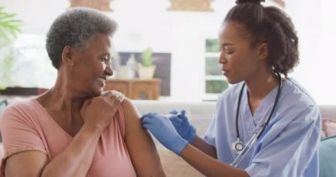 Afro-amerikan kadın doktor, Afrikalı Amerikalı son sınıf öğrencisine iğne yapıyor. tıbbi sağlık hizmeti kavramı