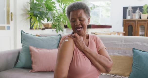 Eine Afroamerikanische Seniorin Zeigt Die Bandhilfe Auf Ihrer Schulter Die — Stockvideo