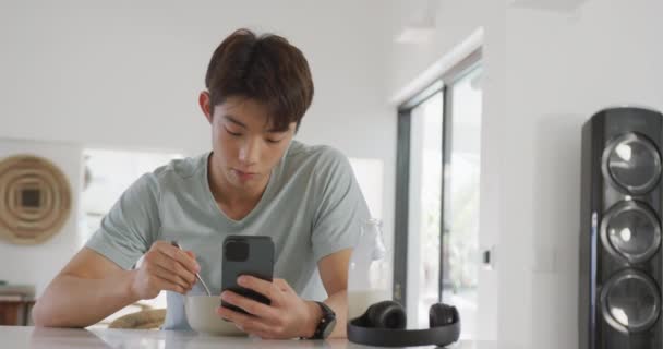 Asian Boy Using Smartphone While Having Breakfast Living Room Home — Stok video