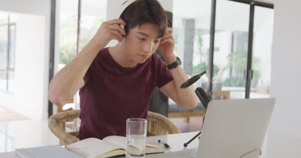 Asiatischer Junge Mit Kopfhörern Der Auf Einem Professionellen Mikrofon Spricht — Stockvideo