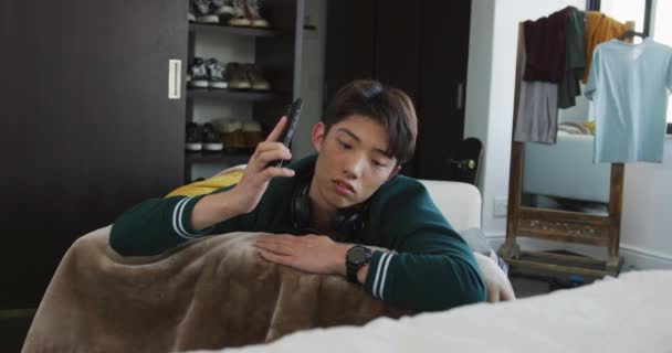 Chico Asiático Hablando Smartphone Tumbado Sofá Casa Estilo Vida Adolescente — Vídeos de Stock