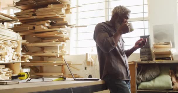 Carpintero Masculino Afroamericano Usando Smartphone Mientras Bebe Café Una Carpintería — Vídeos de Stock