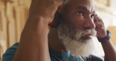 Close up view of african american male carpenter wearing protective ear-muffs in a carpentry shop. carpentry, craftsmanship and handwork concept