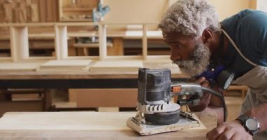 Afrikalı Amerikalı erkek marangoz bir marangozhanede tahta öğütücü kullanıyor. Marangozluk, işçilik ve el işi konsepti