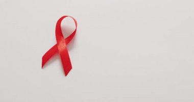 Video of red blood cancer ribbon on white background. medical and healthcare awareness support campaign symbol for blood cancer.