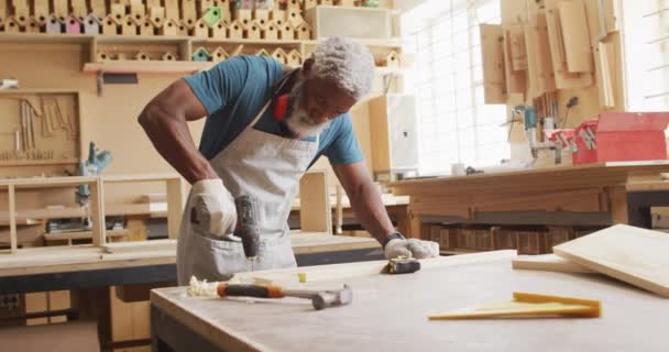 African American Male Carpenter Drilling Holes Wooden Plank Using Hand — Wideo stockowe