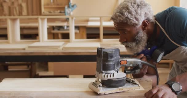 Carpintero Masculino Afroamericano Usando Una Amoladora Eléctrica Para Moler Tablón — Vídeos de Stock