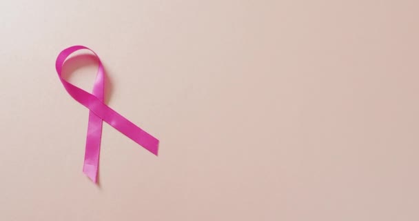 Video Von Rosa Brustkrebsband Auf Blassrosa Hintergrund Unterstützungskampagne Für Brustkrebs — Stockvideo