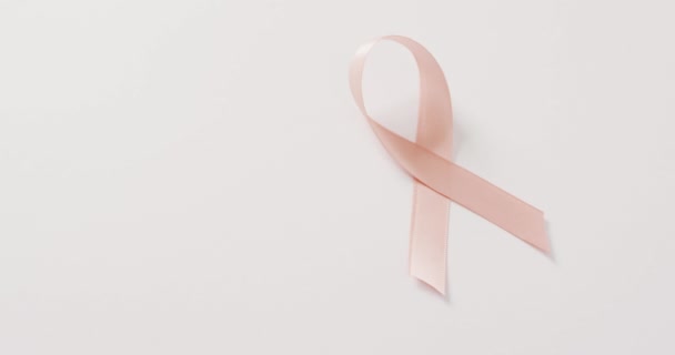 Vídeo Fita Câncer Uterino Rosa Pêssego Fundo Branco Símbolo Campanha — Vídeo de Stock