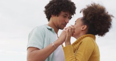 Afrika kökenli Amerikalı çiftin deniz kenarındaki kayalıklarda dans edişini yakından izleyin. Aşk ve ilişki kavramı