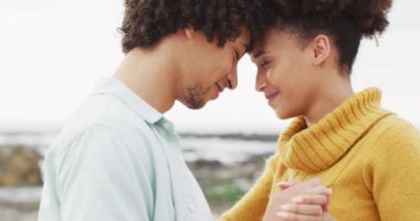 Afrika kökenli Amerikalı çiftin deniz kenarındaki kayalıklarda dans edişini yakından izleyin. Aşk ve ilişki kavramı