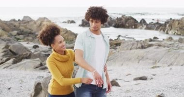 Afrika kökenli Amerikalı bir çiftin deniz kenarındaki kayalıklarda birbirlerine sarılışının portresi. Aşk ve ilişki kavramı