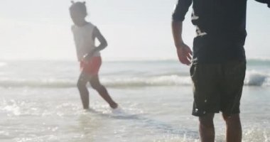 Sahilde eğlenen Afro-Amerikan erkek ve kız kardeşlerin dikiz görüntüsü. Aile seyahati ve tatil konsepti