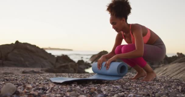 Femme Afro Américaine Roulant Son Tapis Yoga Sur Les Rochers — Video