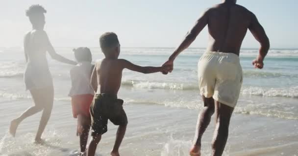 Tylny Widok Afrykańskiej Rodziny Trzymającej Się Ręce Biegające Razem Plaży — Wideo stockowe