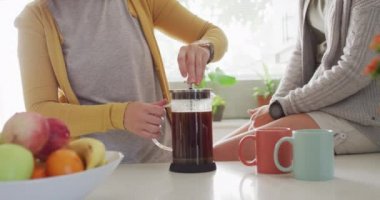 Beyaz lezbiyen çift evdeki mutfakta birlikte kahve yapıyorlar. lgbt ilişkisi ve yaşam tarzı konsepti