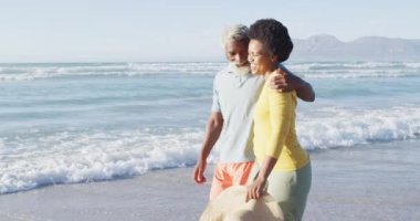 Mutlu Afro-Amerikan çifti güneşli sahilde yürüyüp konuşuyor. sağlıklı ve aktif zaman plaj tatili.