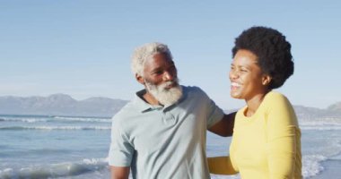 Mutlu Afro-Amerikan çifti güneşli sahilde yürüyor ve kucaklaşıyor. sağlıklı ve aktif zaman plaj tatili.