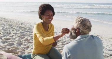 Mutlu Afro-Amerikan çifti güneşli sahilde piknik yapıyor. sağlıklı ve aktif zaman plaj tatili.