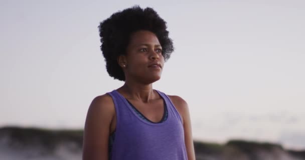 日当たりの良いビーチでスポーツスーツを着た幸せなアフリカ系アメリカ人女性 健康的で活発な時間のビーチホリデー — ストック動画