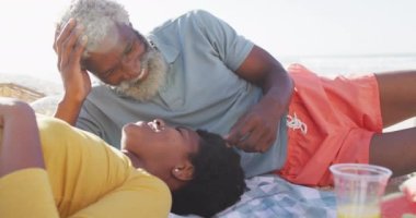 Mutlu Afro-Amerikan çifti güneşli sahilde piknik yapıyor. sağlıklı ve aktif zaman plaj tatili.