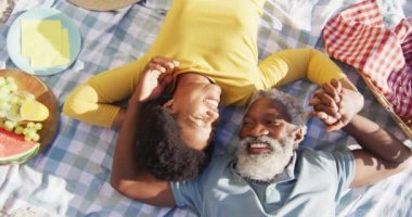 Mutlu Afro-Amerikan çifti güneşli sahilde piknik yapıyor. sağlıklı ve aktif zaman plaj tatili.