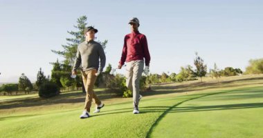 Farklı erkek arkadaşların golf sahasında yürüdüğü bir video. spor, aktif yaşam tarzı ve golf konsepti.