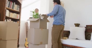 Taşındıktan sonra kutuları açan mutlu çiftin videosu. Aşk, ilişki, taşınma ve birlikte yeni bir hayata başlama kavramı.