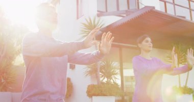 Bahçede Tai Chi egzersizi yapan rahat bir çiftin videosu. Boş zaman, rahatlama, aktif yaşam tarzı ve evde ve bahçe konseptinde boş zaman geçirme.