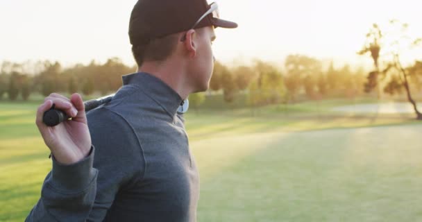 在高尔夫球场上拿着高尔夫球棒的高加索人的视频 运动的 积极的生活方式和打高尔夫球的概念 — 图库视频影像