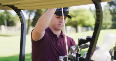 Golf sahasında golf sopasını çantadan çıkaran beyaz bir adamın videosu. spor, aktif yaşam tarzı ve golf konsepti.