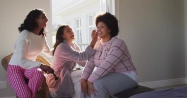 Mutlu çeşitli bayan arkadaşlar makyaj yapıyor ve yatak odasında gülümsüyor. evde kaliteli zaman geçirmek.