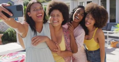 Mutlu çeşitli bayan arkadaşlar yüzme havuzunda selfie çekip gülümsüyor. evde kaliteli zaman geçirmek.