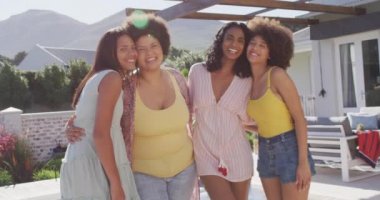 Yüzme havuzu partisinde kucaklaşan ve gülümseyen mutlu kadın arkadaşlarının portresi. evde kaliteli zaman geçirmek.