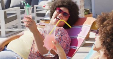 Mutlu çeşitli bayan arkadaşlar yüzme havuzunda tost yapıyor ve gülümsüyor. evde kaliteli zaman geçirmek.