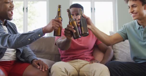快乐多样的男性朋友在客厅里聊天和喝啤酒 一起在家共度美好时光 — 图库视频影像
