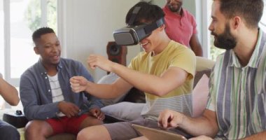 VR kulaklığı takan ve oturma odasında konuşan mutlu erkek arkadaşlar. Birlikte evde kaliteli zaman geçiriyoruz..