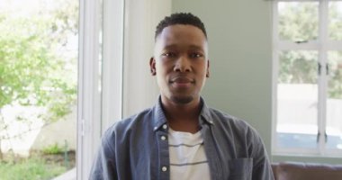 Oturma odasında gülümseyen mutlu bir Afrikalı Amerikalının portresi. Birlikte evde kaliteli zaman geçiriyoruz..